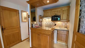 Una cocina con armarios de madera, microondas, fregadero y lavavajillas.