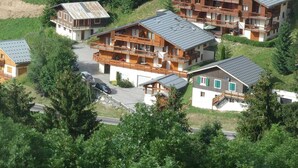 A cluster of wooden buildings with balconies, surrounded by greenery. - Cosy apartment with beautiful view - 4 guests (Arêches-Beaufort)