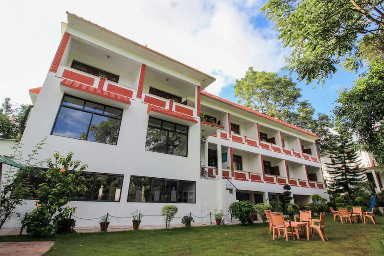 A multi-story building with balconies, a lawn, and outdoor seating.