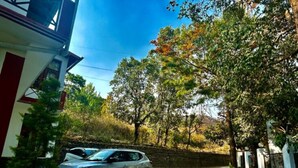 Une allée pavée mène à un bâtiment devant lequel est garée une voiture.