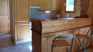 Une cuisine en bois avec un coin bar, des meubles de rangement en bois et une fenêtre.