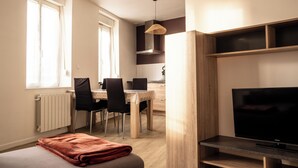 Una cocina moderna con comedor, televisión y ventana.