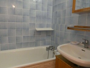 A bathroom with a bathtub, a sink, and a mirror. - Cozy studio, pets welcome - 4 guests (Arêches-Beaufort)