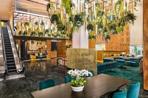 A modern lobby with a marble floor, a reception desk, seating areas, and an escalator. - Perfect LA Escape | Pool, Pets Allowed | Walt Disney Concert Hall - 0.9 mile (Los Angeles)
