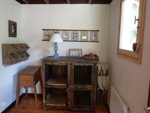 A rustic room with a wooden desk, a small stool, and a shelf with framed pictures. - Comfortable chalet central in Arêches - 8 guests (Arêches-Beaufort)