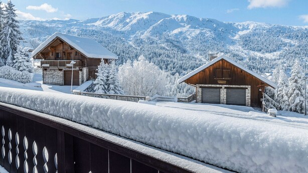 A wooden cabin with a stone foundation, a garage, and a balcony overlooking snow-covered mountains. - Family apartment, balcony - 6 guests (Méribel)
