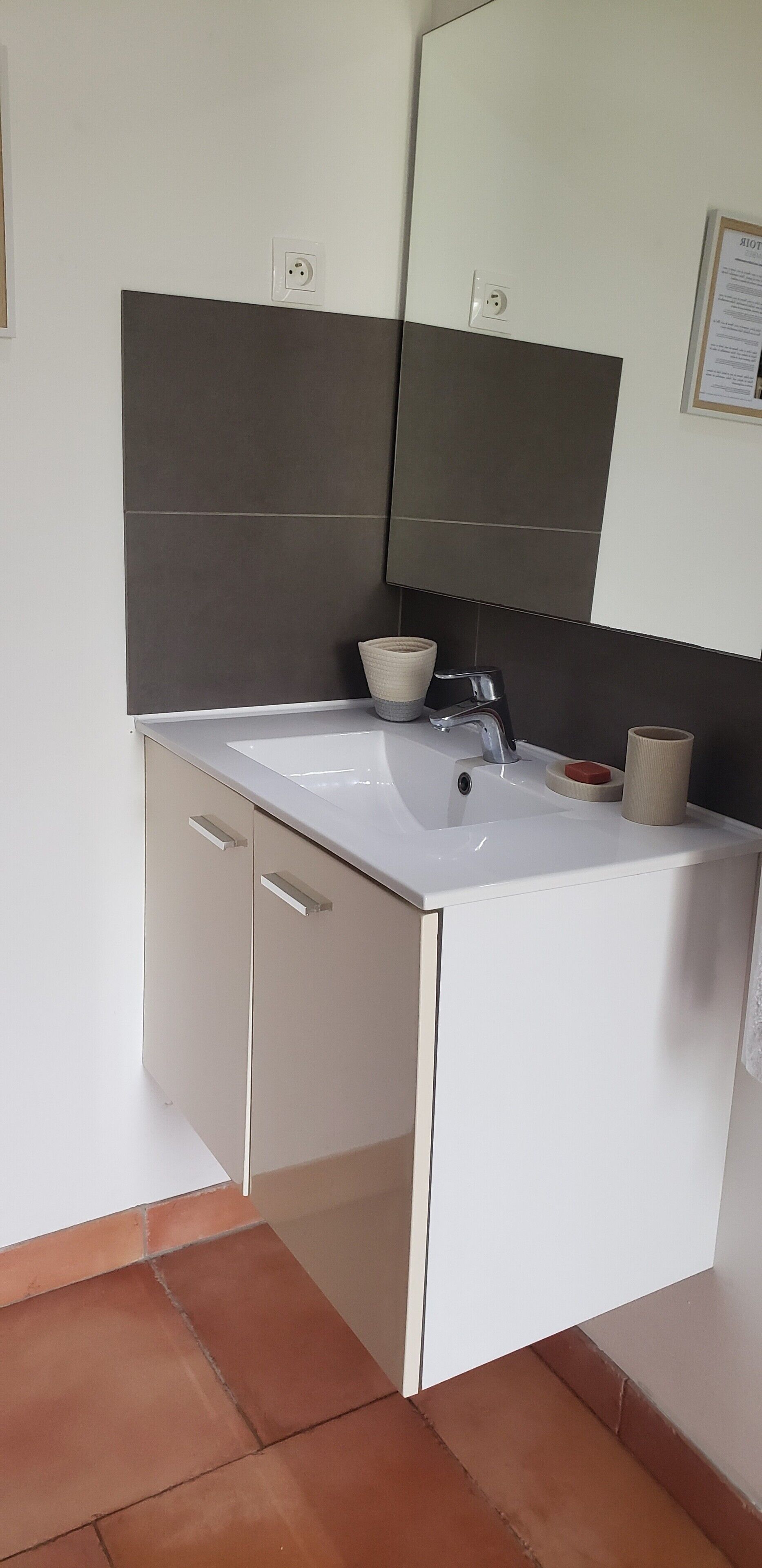 A bathroom with a white sink, a mirror, and a cabinet.