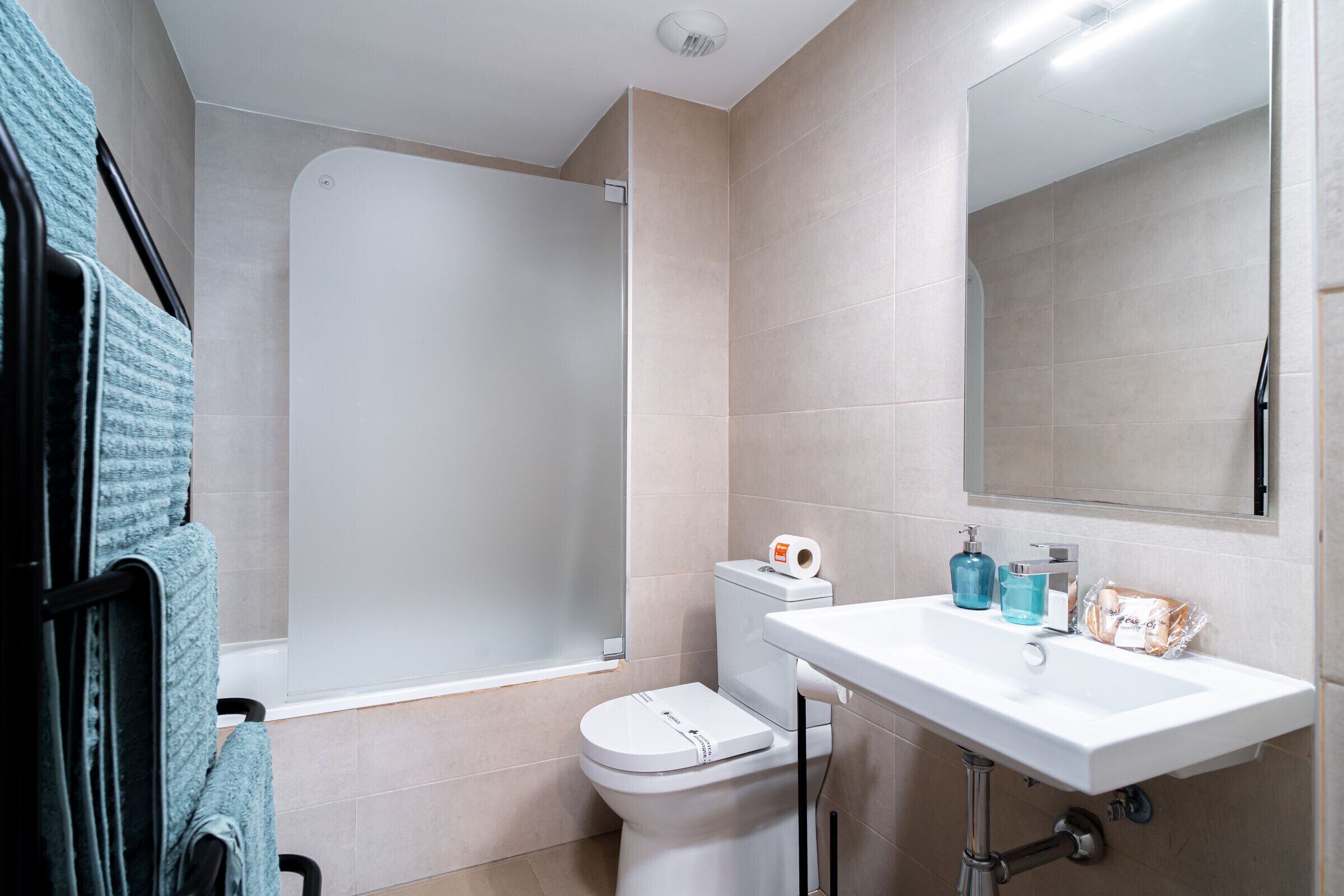 A bathroom with a toilet, sink, and shower.