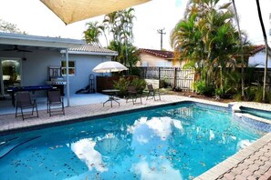 A swimming pool with lounge chairs and a barbecue area, surrounded by palm trees. - Luxury Escape w/ Pool & Billiards • Near Beach (Hollywood)
