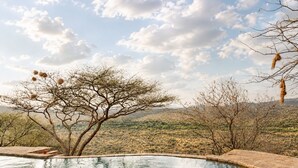 A pool with a clear view of a dry, hilly landscape in the background. - Nasuulu lodge (Isiolo)