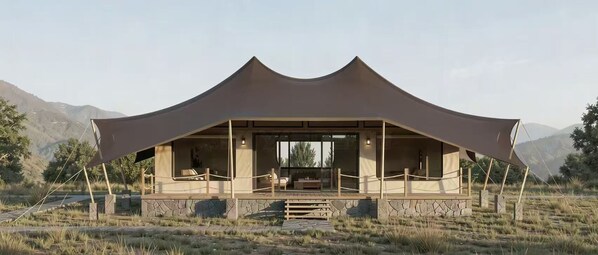 A tent-like structure with a covered patio area, stone steps, and a view of mountains.
