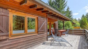 A wooden cabin with large windows, a deck with outdoor furniture, and a covered patio area. - 2 bedroom gorgeous home in Merzalben (Merzalben)