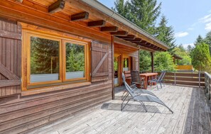 A wooden cabin with large windows, a deck with outdoor furniture, and a covered patio area. - 2 bedroom gorgeous home in Merzalben (Merzalben)