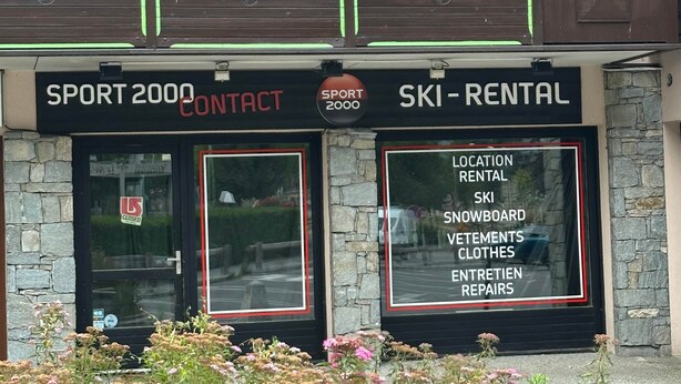 A building with a sign for 'SPORT 2000 CONTACT' and 'SKI RENTAL' services. - Chamonix Town Centre Apartment with Free Parking (Chamonix-Mont-Blanc)