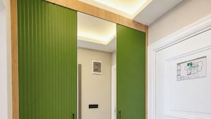 A hallway with a mirrored closet door, a white door with a map, and a light switch on the wall. - Ovva Inn Yeşilovacık Hotel (Silifke)