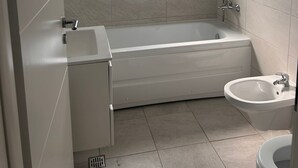 Une salle de bain avec une baignoire, une douche, un lavabo et des toilettes.