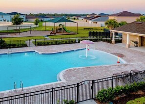 A swimming pool with a fountain, surrounded by a paved deck and a fence. - 10 Mi to Wdw! Group Retreat w/ Patio & Grill (Davenport)