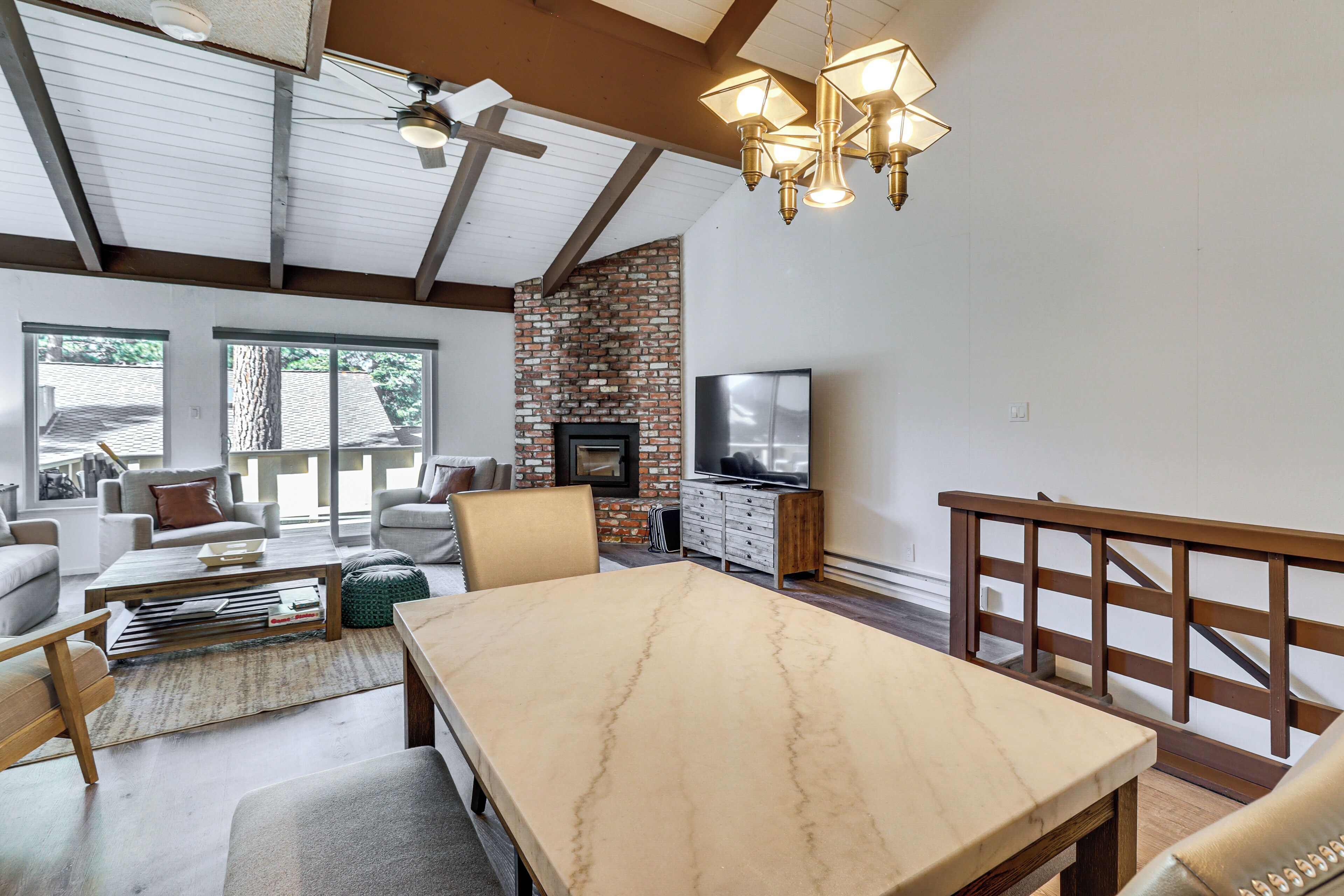 A spacious living area with a fireplace, a dining table, and comfortable seating.