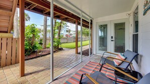 A covered patio with a brick floor, outdoor seating, and a view of the street. - Walk to Beach at the End of the Street! (St. Augustine)