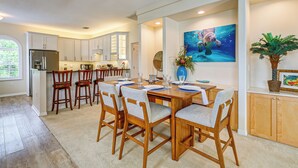 A modern kitchen with a dining area, wooden cabinets, and a ceiling fan. - Scallop HQ: 3 Boat Docks and Free Golf Cart! (Homosassa)