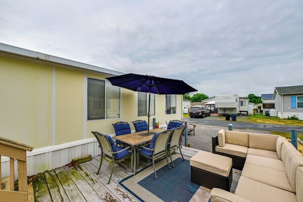 A covered patio with a table and chairs, a sofa, and an umbrella. - Pool + Bay Access! Home 13 Mi to Ocean City Beach (Berlin)