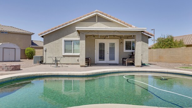 A house with a swimming pool, a covered patio, and a garage. - Pool, Games, Fenced Yard! Extended Stay in Buckeye (Buckeye)