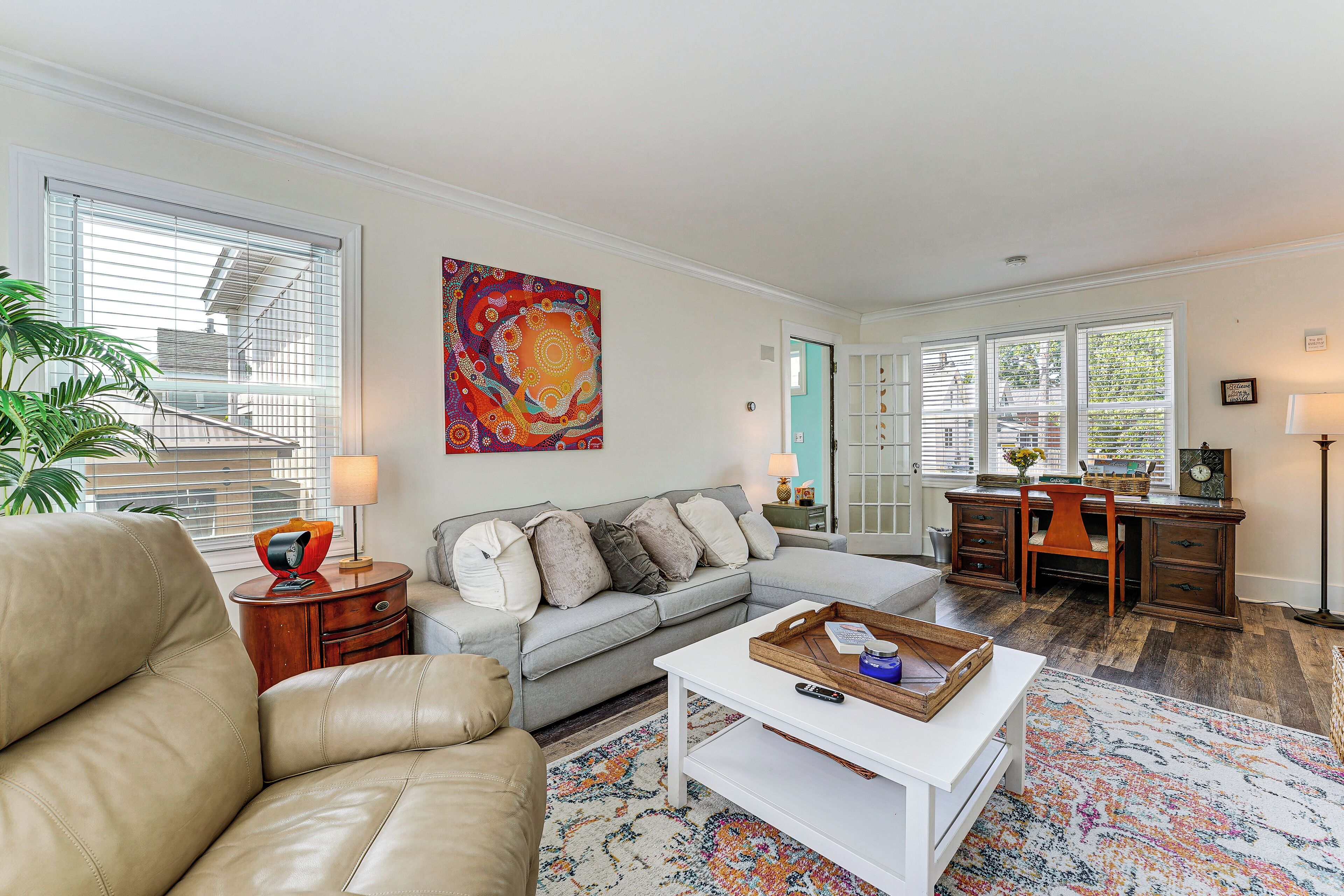 A living room with a sofa, coffee table, and a desk with a chair.