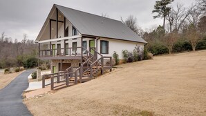 A modern two-story house with a balcony, a covered porch, and a staircase leading to the upper level. - Boat Dock & Deck! Lake Guntersville Family Escape (Guntersville)