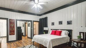A bedroom with a bed, a ceiling fan, a nightstand, a lamp, and a small table with a plant. - Family-friendly Retreat w/ Fireplaces in Greenwood (Greenwood)