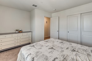 A bedroom with a bed, dresser, and two doors. - Private Pool & Patio! Family Getaway in Stockton (Stockton)