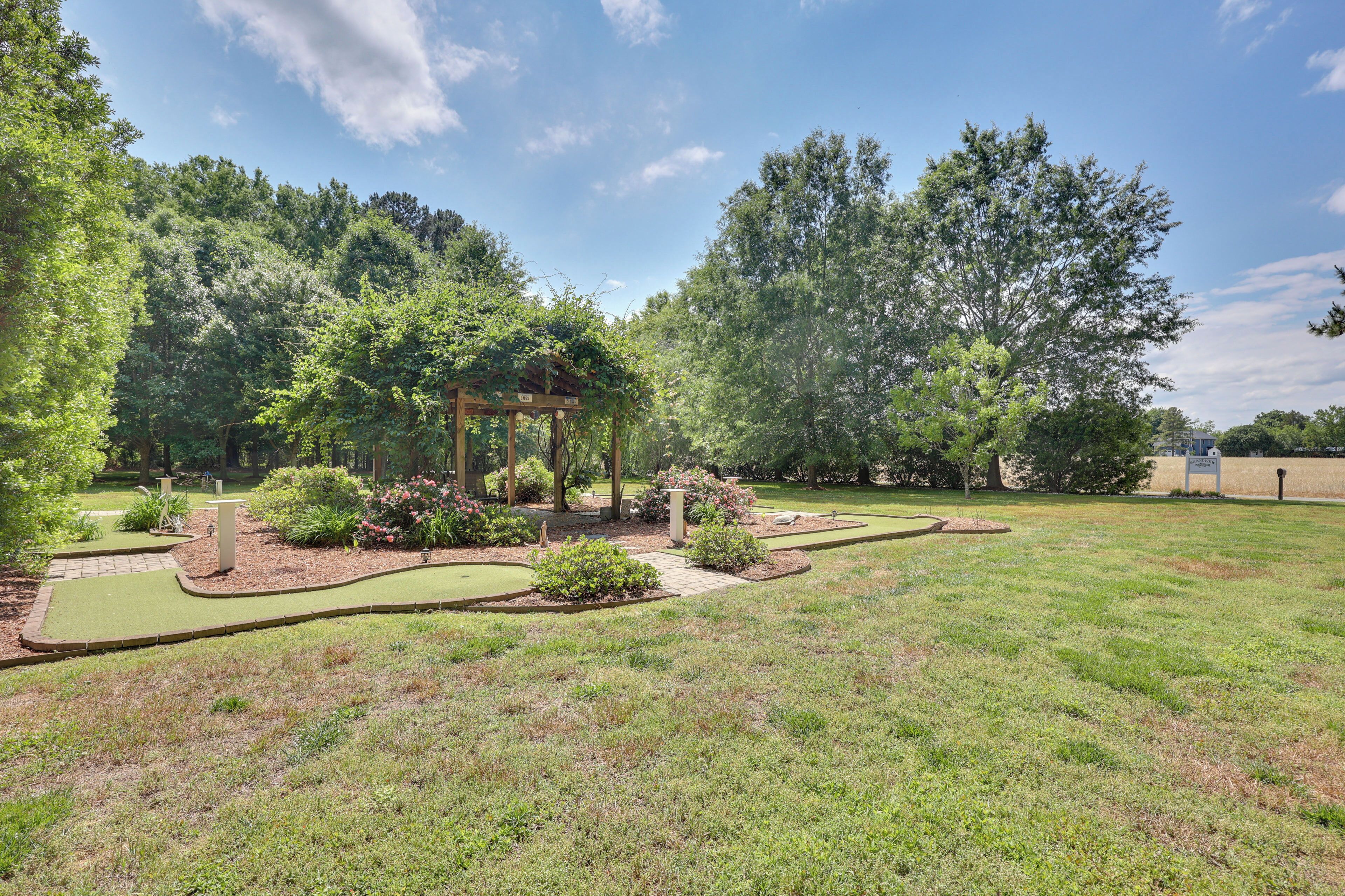 A well-maintained garden with a gazebo, manicured lawn, and a putting green.