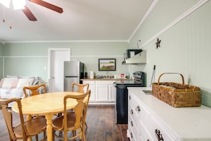 A kitchen with a wooden dining table and chairs, a refrigerator, a microwave, and a stove. - Steps to Nauvoo Temple! 2-unit Family Combo (Nauvoo)