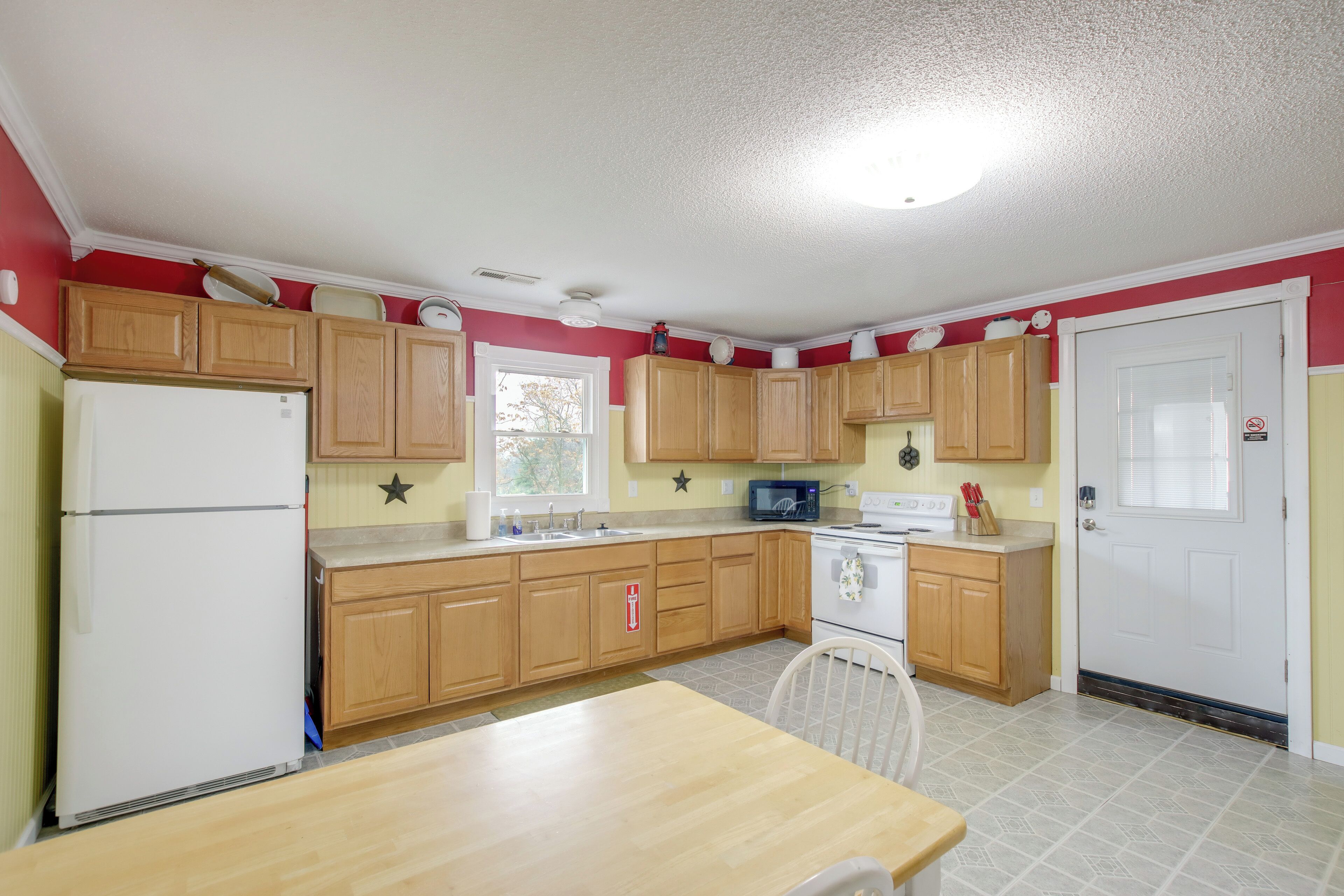 A kitchen with wooden cabinets, a white refrigerator, a microwave, and a stove.