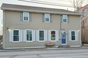A two-story building with a blue door, a bench outside, and a sign above the door. - Steps to Nauvoo Temple! 2-unit Family Combo (Nauvoo)
