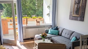 Ein modernes Wohnzimmer mit einem grauen Sofa, einem Holztisch und einem Holzstuhl.