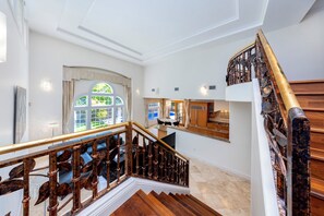 Eine Treppe mit Holzgeländer und Blick auf einen Essbereich mit Tisch und Stühlen.