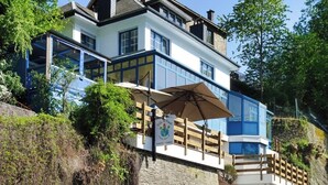 A multi-story building with a balcony, a sign, and a wooden fence. - Charming villa with panoramic views. (La Roche-en-Ardenne)