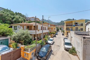Un carrer estret flanquejat per edificis residencials, alguns amb balcons i d'altres amb jardins davanters.