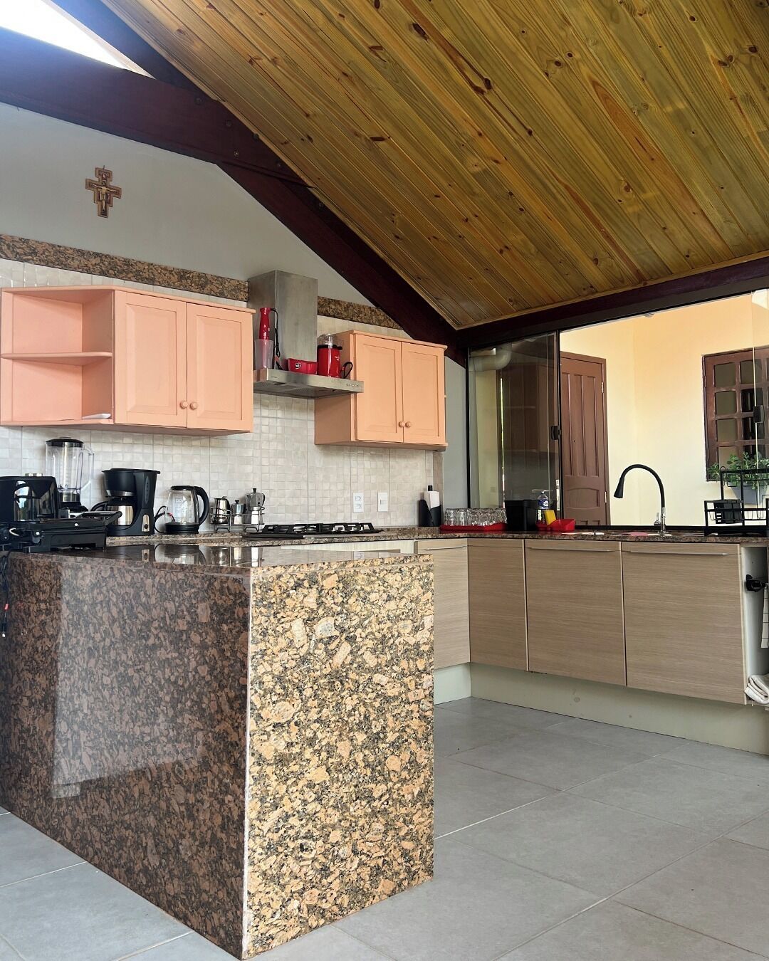 A kitchen with granite countertops, wooden cabinets, and a wooden ceiling.