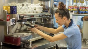 En person som använder en espressomaskin i en kommersiell miljö.