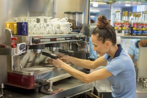 A person operating an espresso machine in a commercial setting. - Montecielo 4E 3 bdrs ocean view in Los Suenos (Herradura)