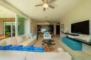 A modern living room with a sofa, coffee table, and TV. - Montecielo 4E 3 bdrs ocean view in Los Suenos (Herradura)
