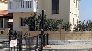 A two-story house with a balcony, a gated entrance, and a sign indicating private property. - Beautiful Sea Views Private Pool 3 Bed Beach Villa (Perivolia)