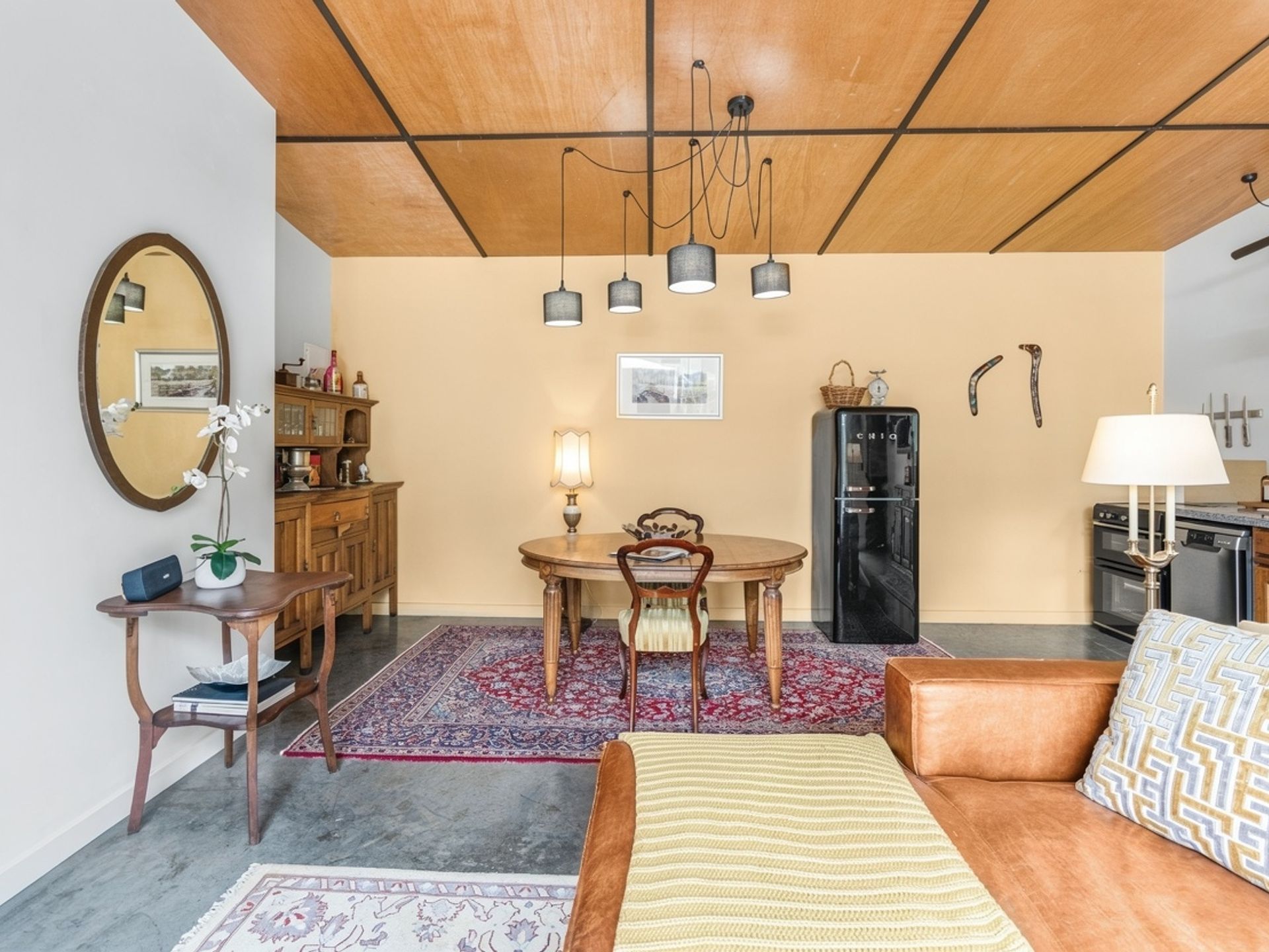 Espaço compacto com área de refeições, cozinha compacta e sofá.