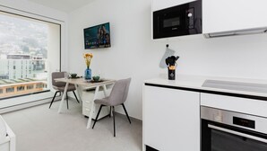 Eine moderne Küche mit Mikrowelle, Backofen und Essbereich mit Stühlen und einem Tisch.