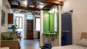A bedroom with a bed, a green tiled sink, a wooden ceiling, and a view to the dining area. - A comfortable 34 square-meter studio apartment that sleeps up to three people, located on the ground floor of a renovated building.The property enjoys a strategic location just steps from Ravenna's historic center, in a quiet residential area well-served (Ravenna)
