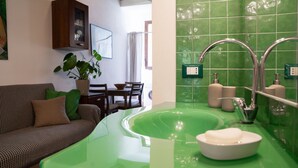 A modern bathroom with a green sink, two faucets, and a mirror. - A comfortable 34 square-meter studio apartment that sleeps up to three people, located on the ground floor of a renovated building.The property enjoys a strategic location just steps from Ravenna's historic center, in a quiet residential area well-served (Ravenna)