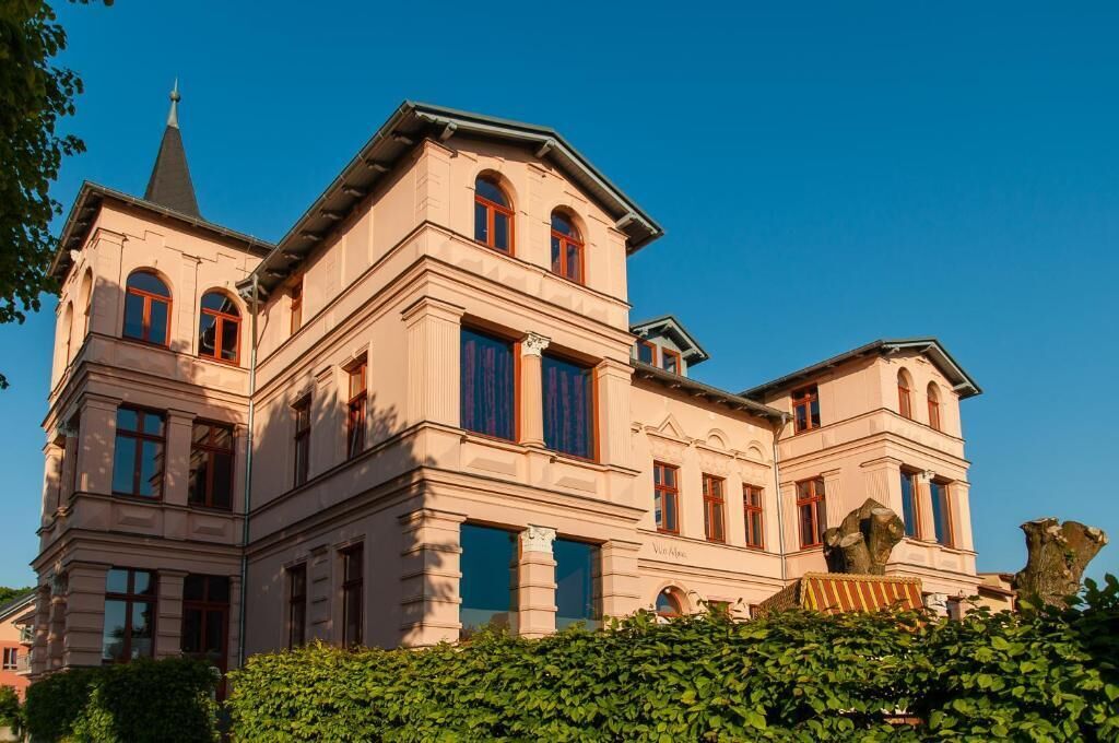 Ein großes, mehrgeschossiges Gebäude mit einem markanten Turm und Rundbogenfenstern.