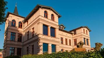 Ein großes, mehrgeschossiges Gebäude mit einem markanten Turm und Rundbogenfenstern.