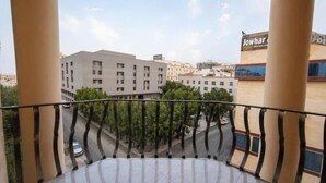 Un balcón con vistas a un paisaje urbano, con edificios y una calle.